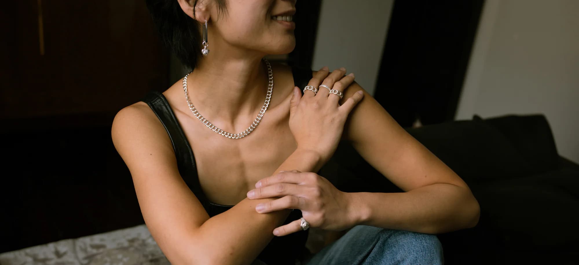 Luxury jewelry collection featuring elegant woman wearing silver jewelry